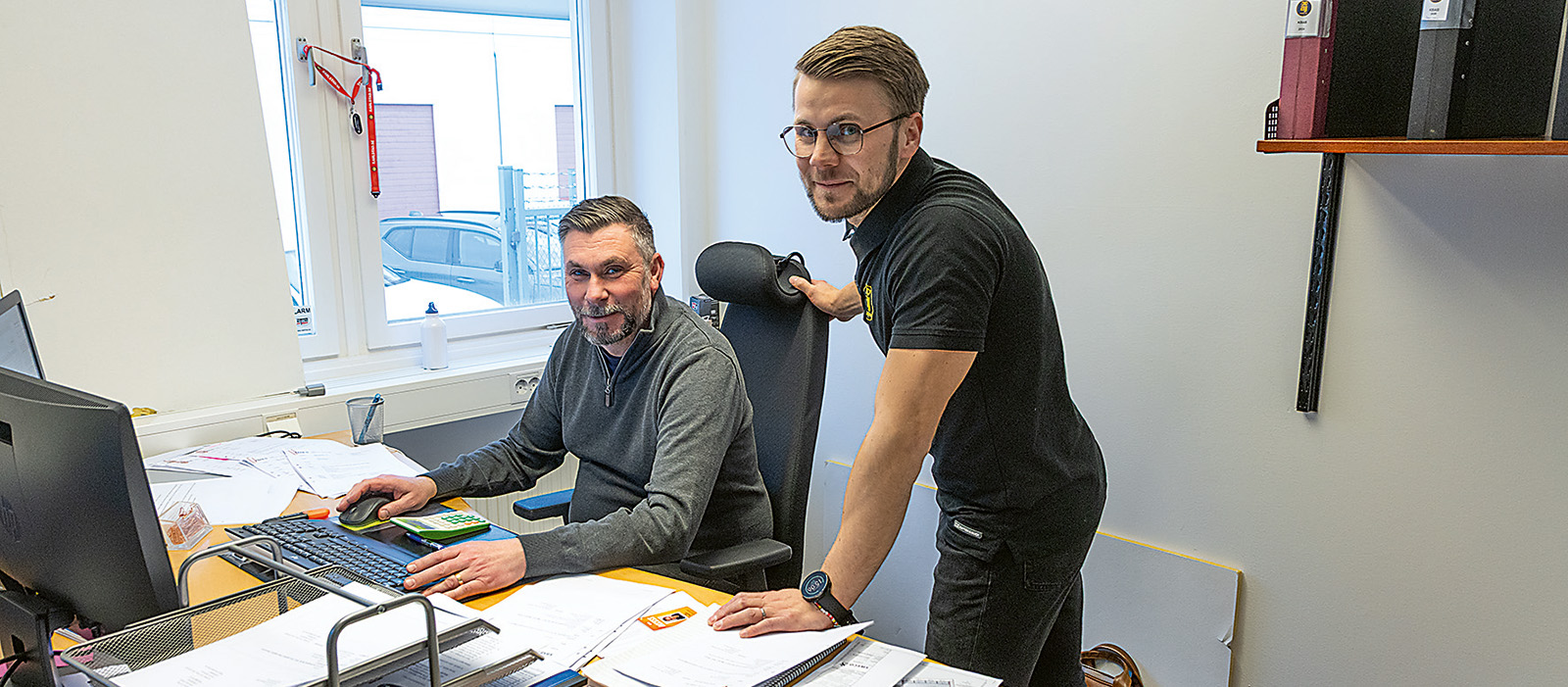 Tv&aring; m&auml;n diskuterar vid en dator